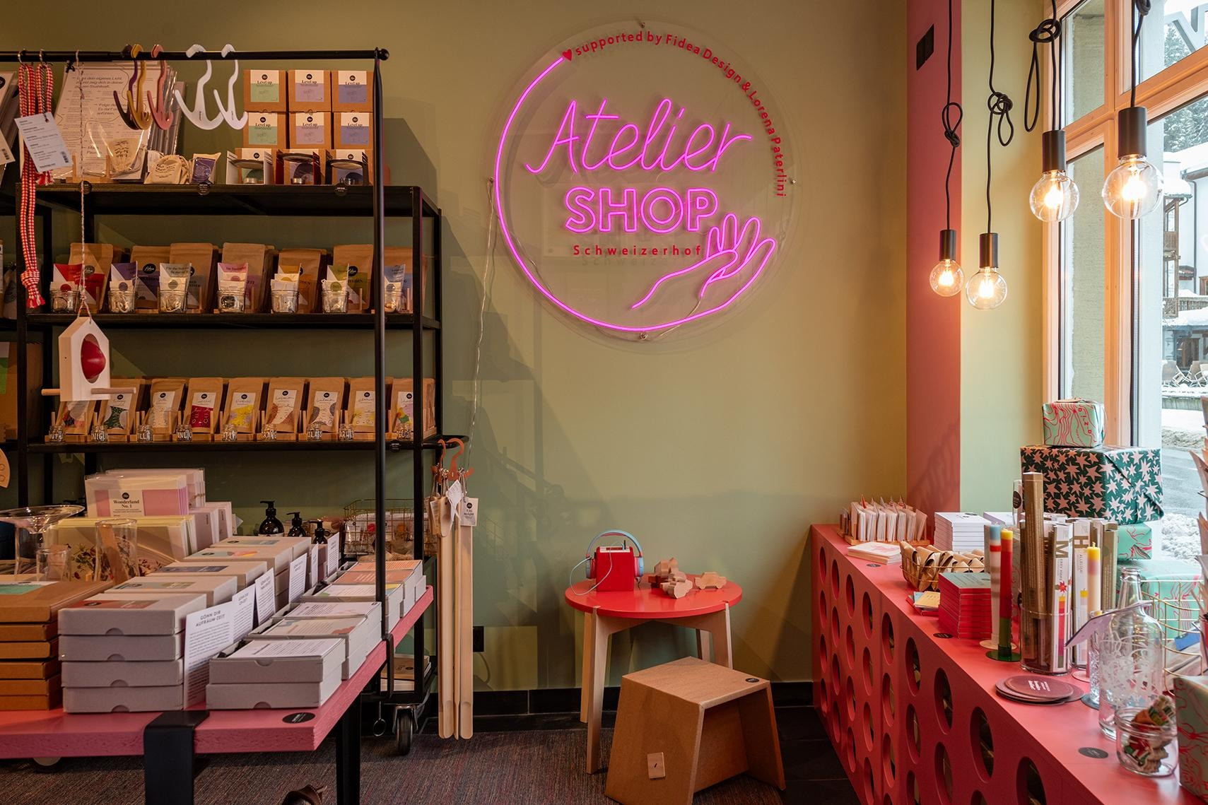 Modern eingerichteter Shop mit farbenfrohen Produkten, Neon-Schild und stilvollen Deko-Elementen.