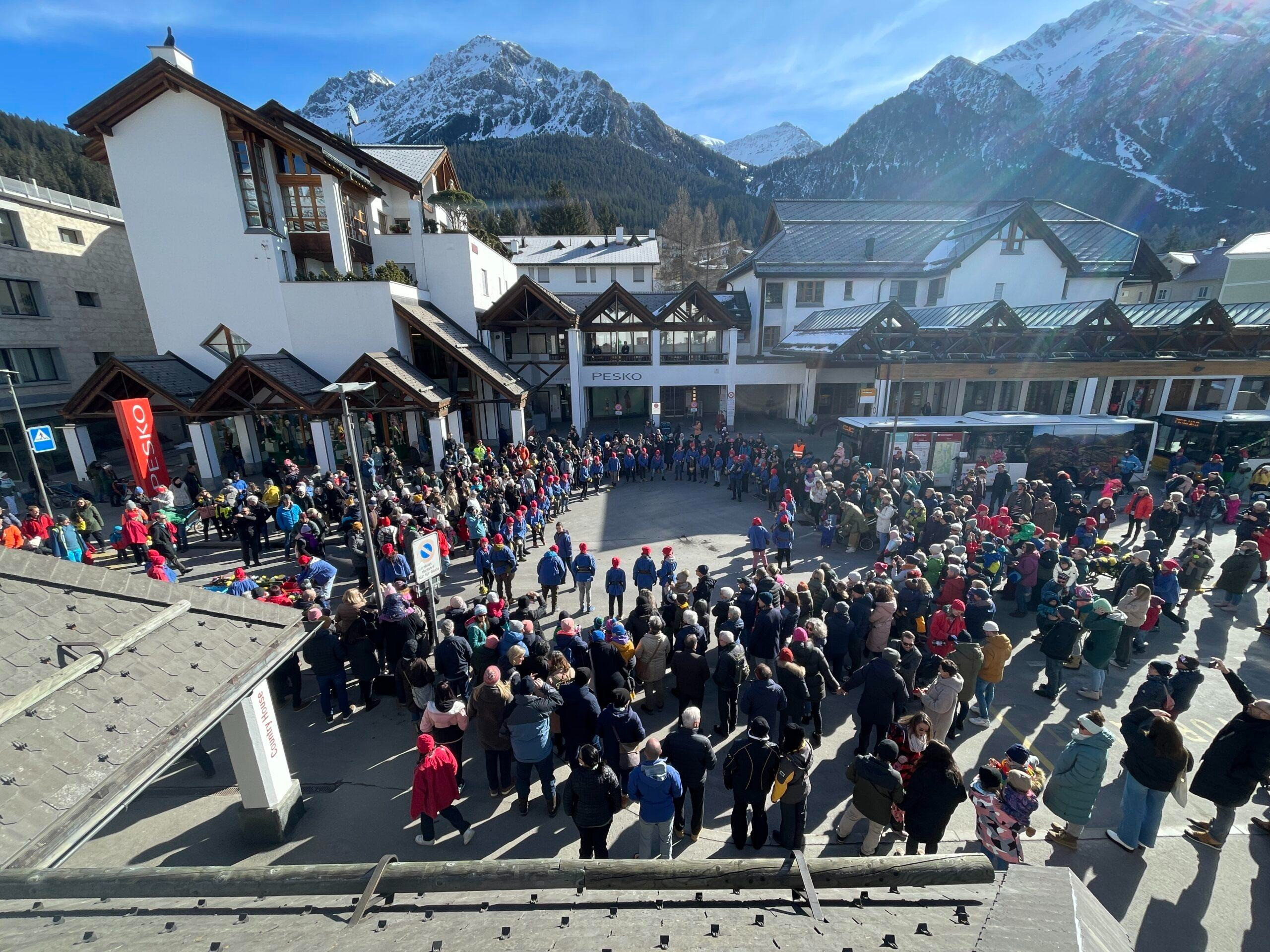 Menschenmenge bei einem Winterevent in der Lenzerheide-Bergkulisse.