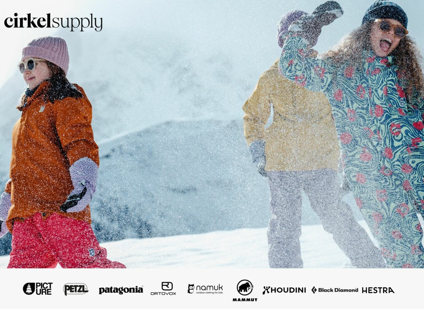 Kinder spielen fröhlich im Schnee mit bunter Winterkleidung.