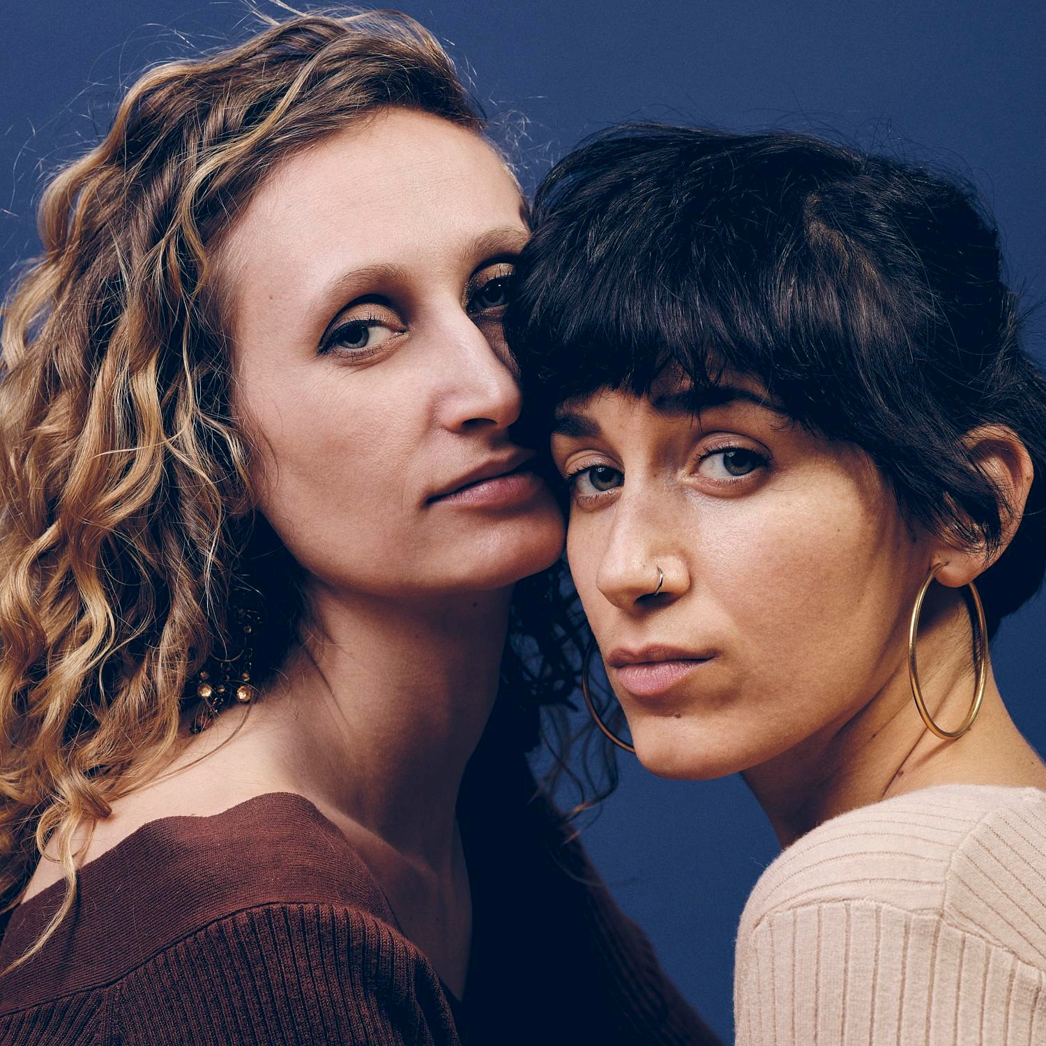 Zwei Frauen die in die Kamera schauen.