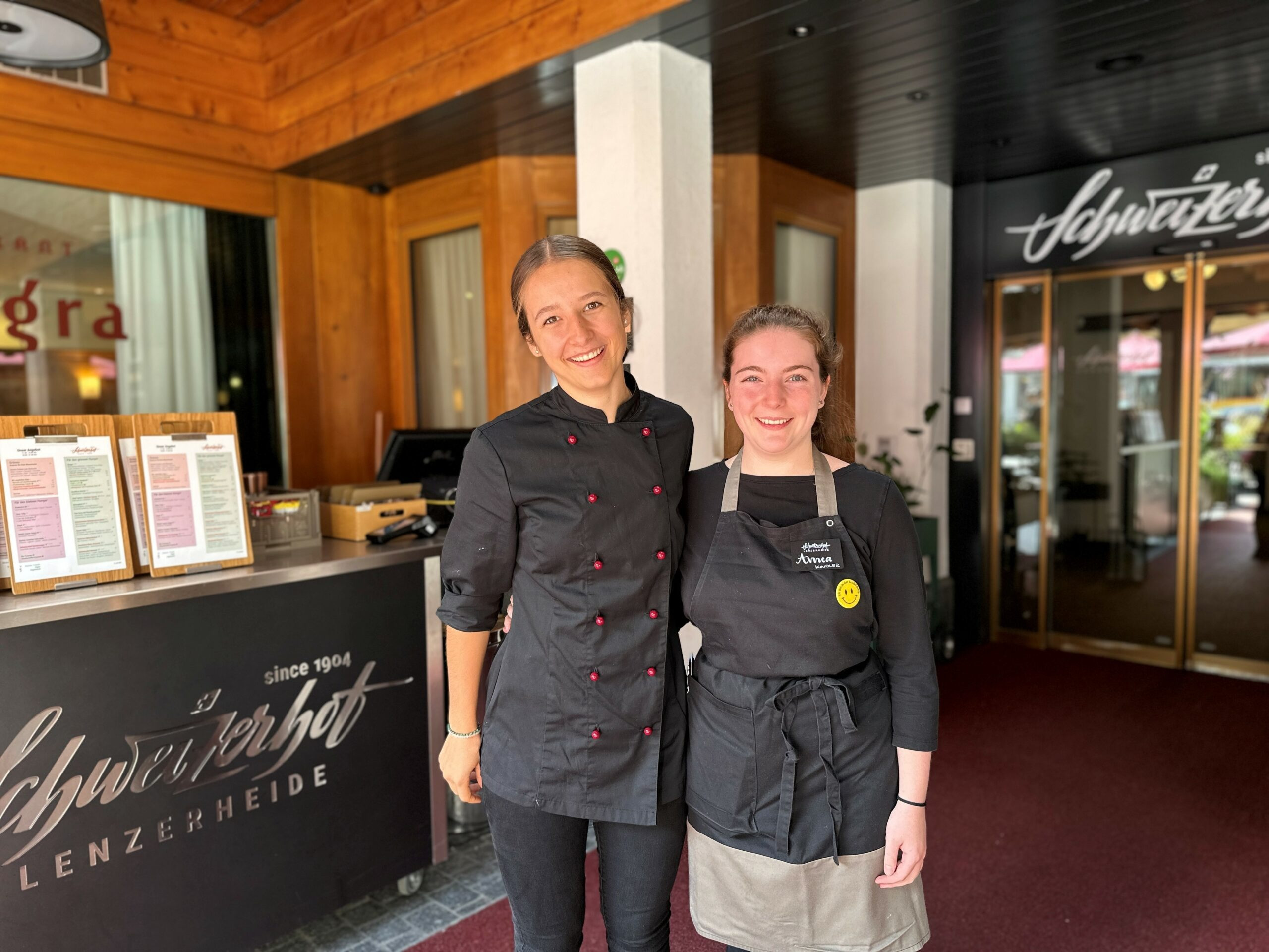 Mitarbeitende des Hotels die Seite an Seite stehen und in die Kamera lachen.