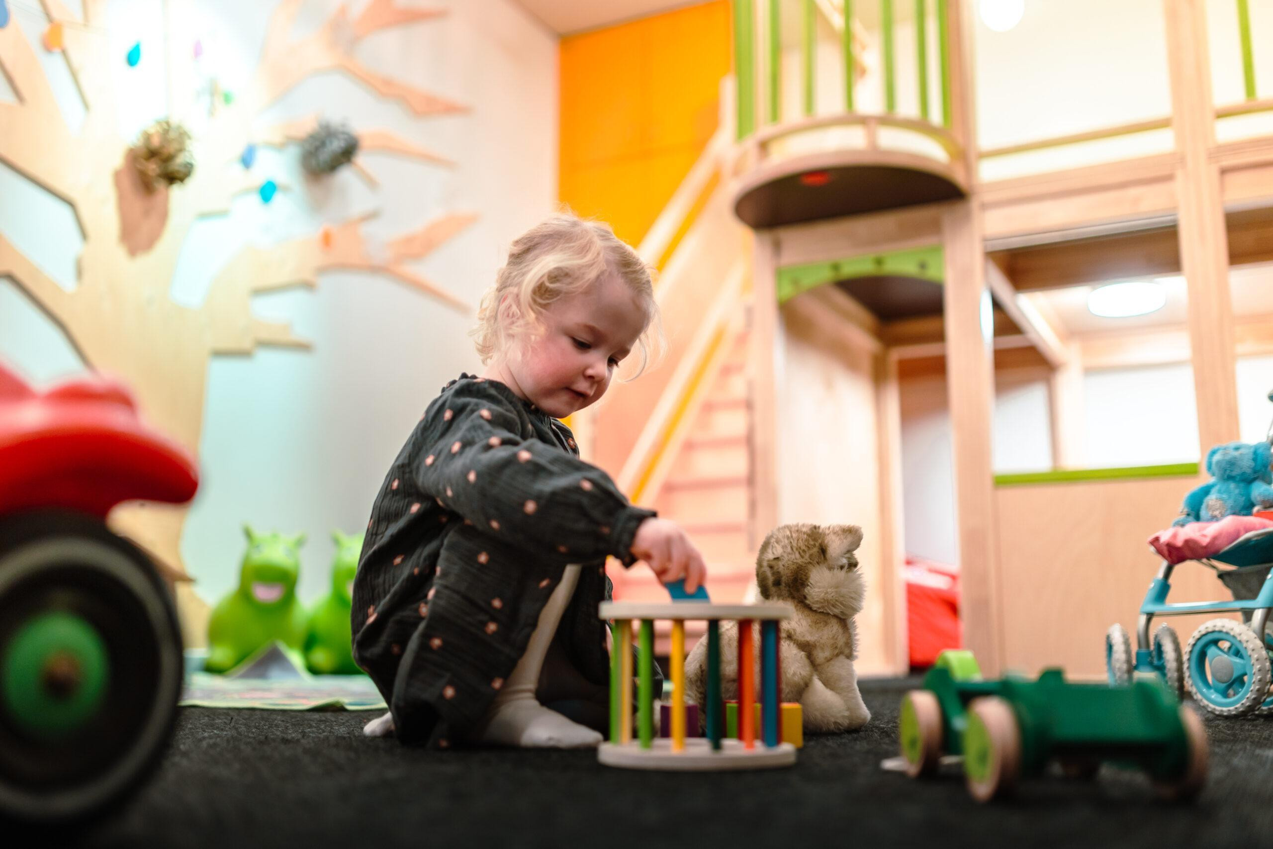 Ungefähr vier jähriges Kind auf dem Boden am Spielen