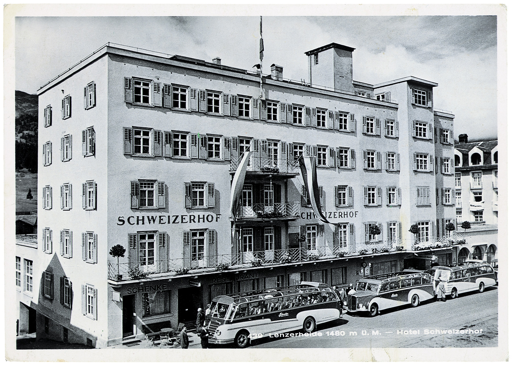 Historische Aufnahme des Hotel Schweizerhof in Lenzerheide mit Reisebussen und Gästen vor dem Gebäude.