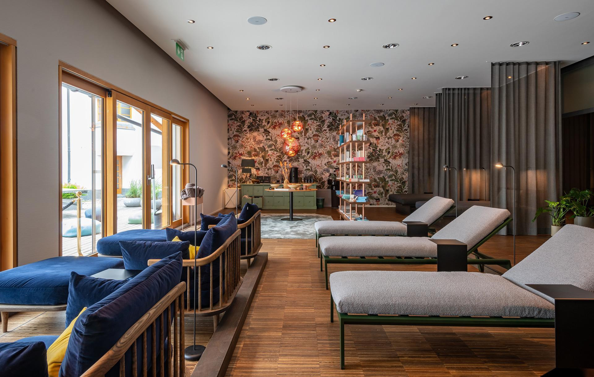 Ruheraum mit vielen Sitz- und Liegemöglichkeiten sowie Regal mit Kosmetikprodukten