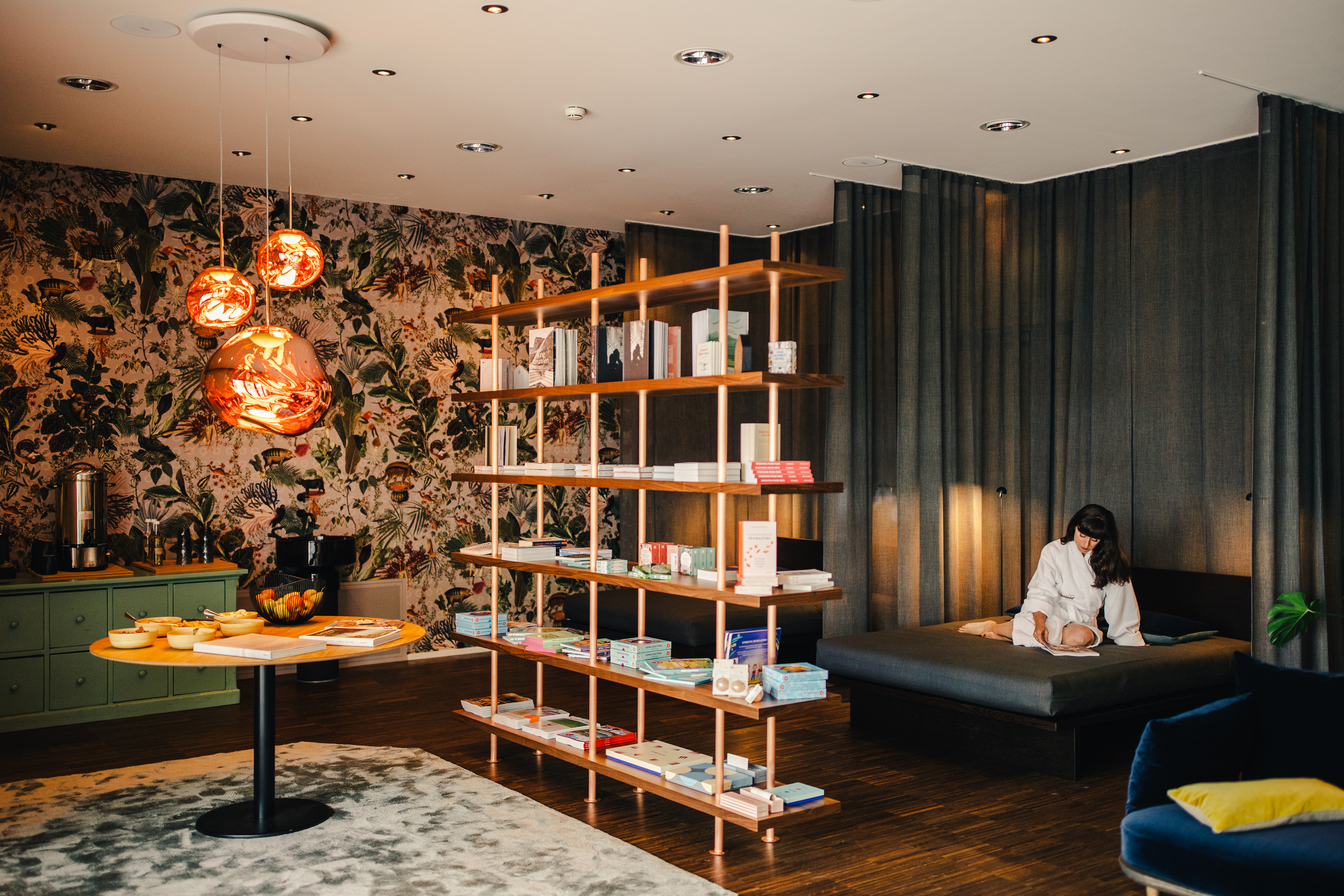 Eine Dame sitzt im Entspannungsraum und liest ein Buch.