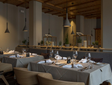 Feines Restaurant im Hotel Schweizerhof Lenzerheide mit elegantem Interieur, modernen Leuchten und stilvoller Atmosphäre