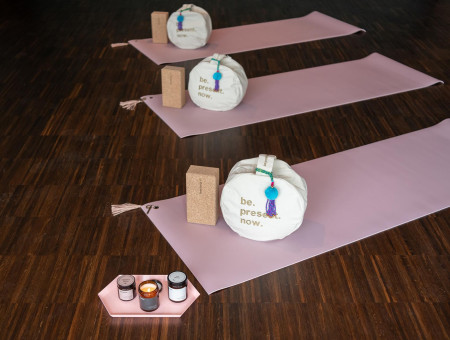 Yoga-Setup im Hotel Schweizerhof Lenzerheide mit Matten, Meditationskissen und Kerzen für achtsame Entspannung im Wellnessbereich