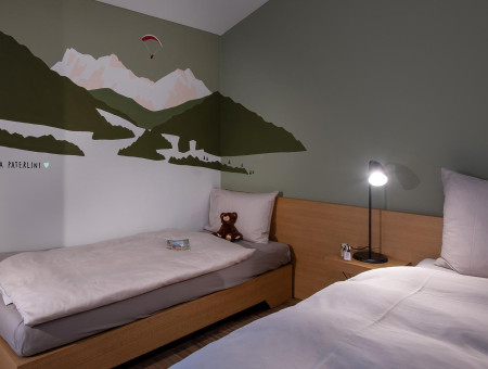 Budget Zimmer im Hotel Schweizerhof Lenzerheide mit zwei Betten und handgemalter Berglandschaft von Lorena Paterlini für wohnliches Ambiente