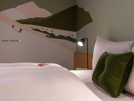 Gemütliches Budget Zimmer im Hotel Schweizerhof Lenzerheide mit Kunstwand von Lorena Paterlini und stilvollem Alpen-Design
