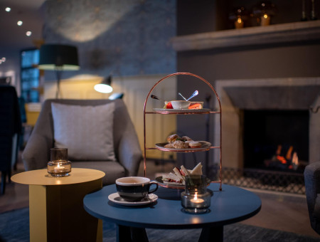 Einladende Hotellobby im Hotel Schweizerhof Lenzerheide mit Kamin, stilvollen Sitzgruppen und modernem Interieur für behagliche Stunden