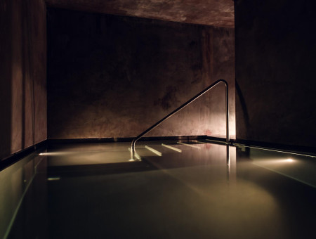 Stimmungsvoll beleuchtetes Tauchbecken im Wellnessbereich des Hotel Schweizerhof Lenzerheide für Erfrischung nach Sauna und Hamam