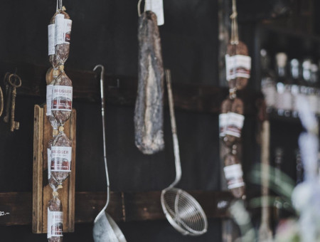 Detailaufnahme der Vorratswand im Scalottas Terroir Lenzerheide mit Gewürzgläsern und regionalen Wurstspezialitäten