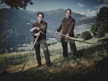 Zwei Köche mit Heugabeln auf Bergwiese – Verbundenheit mit der Natur im Scalottas Terroir Lenzerheide