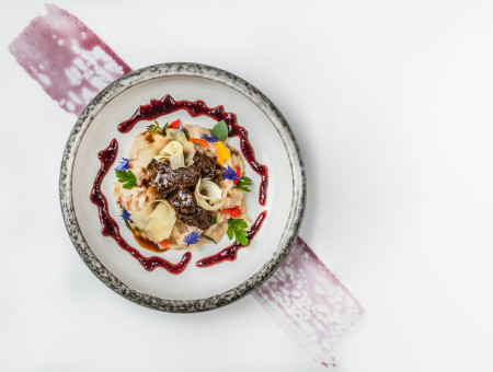 Gourmetgericht mit Rind, Gemüse und Blütendekor – kunstvolle Kulinarik aus dem Scalottas Terroir Lenzerheide