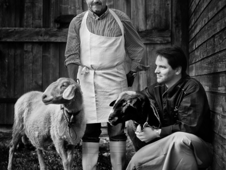 Zwei Männer mit zwei Schafen vor alter Scheune – nachhaltige Tierhaltung im Scalottas Terroir Lenzerheide