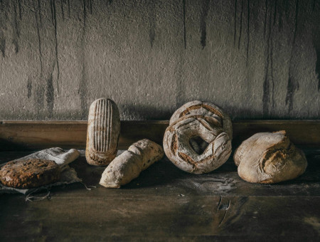 Verschiedene handwerklich gebackene Brote auf Holztisch – traditionelle Backkunst im Scalottas Terroir Lenzerheide