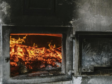 Brennender Holzofen mit lodernden Flammen – traditionelles Backen mit Feuer im Scalottas Terroir Lenzerheide