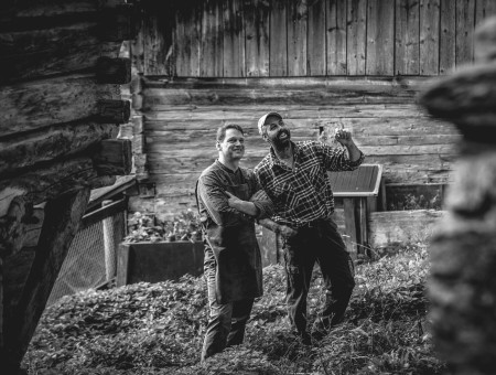 Zwei Männer im Gespräch vor Bauernhaus – nachhaltige Landwirtschaft und Kooperation für das Scalottas Terroir Lenzerheide