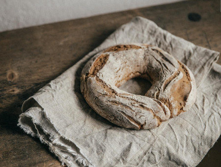 „Rundes Bauernbrot auf Leinentuch – traditionelles Backhandwerk im Scalottas Terroir Lenzerheide