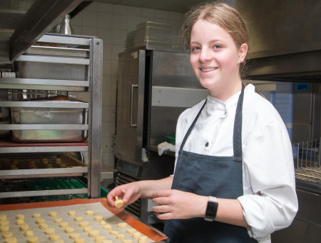 Teilnehmerin des Behind the Scenes Programms backt in der Hotelküche im Schweizerhof Lenzerheide