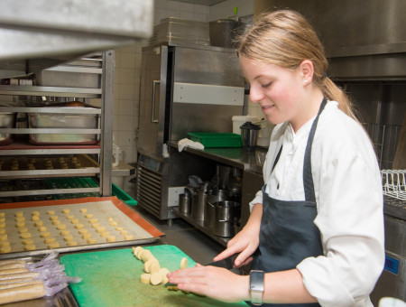 Schülerin schneidet Teigrollen in der Küche – Einblick ins Berufsleben beim Behind the Scenes Programm im Hotel Schweizerhof Lenzerheide