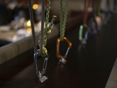 Detailaufnahme im Restaurant im Hotel Schweizerhof Lenzerheide mit bunten Kletterseilen und Karabinern als kreative Raumdekoration
