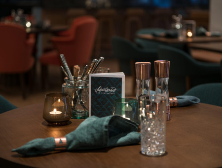 Stimmungsvoll gedeckter Tisch im Restaurant Schweizerhof Lenzerheide mit Kerzenlicht und eleganter Dekoration für genussvolle Momente