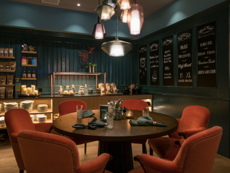 Modernes Restaurant Schweizerhof Lenzerheide mit stilvollen Sitzplätzen, warmem Licht und gemütlicher Atmosphäre für kulinarische Erlebnisse