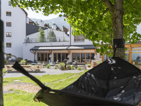 Hotel Schweizerhof Lenzerheide – Gartenlounge mit Hängesitz im Innenhof