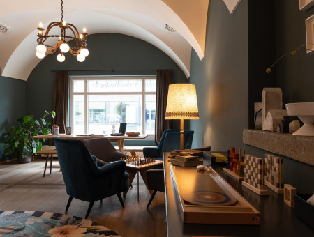 Gemütlicher Aufenthaltsraum im Hotel Schweizerhof Lenzerheide mit Spielen, Leseecke und warmem Licht