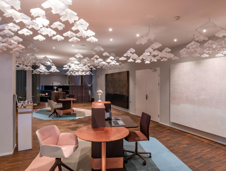 Modern gestalteter Wellnessbereich im Hotel Schweizerhof Lenzerheide mit Kunstinstallation aus weißen Papierobjekten und stilvollen Sitzplätzen für Beratung und Entspannung
