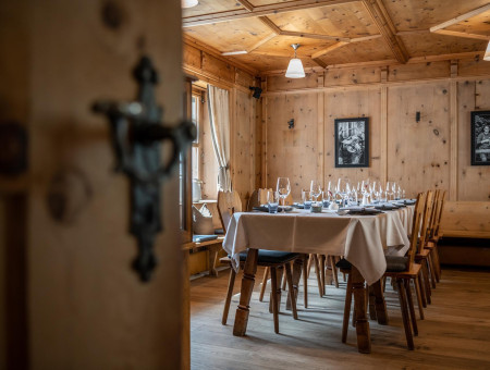 Gemütliche Arvenstube im Scalottas Terroir Lenzerheide mit elegant gedecktem Tisch und traditioneller Holzvertäfelung