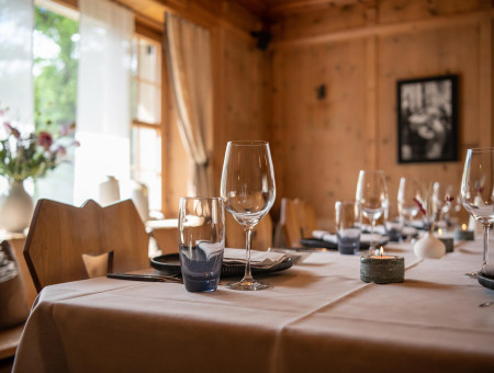 Eleganter Tisch im Scalottas Terroir Lenzerheide mit Sonnenlicht, frischen Blumen und stilvollem Gedeck im Hotel Schweizerhof
