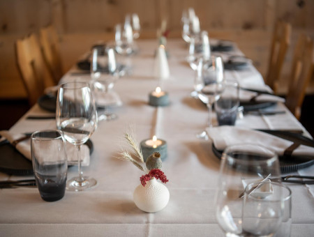 Festlich gedeckter Tisch im Scalottas Terroir Lenzerheide mit Kerzenlicht und minimalistischer Dekoration für genussvolle Abende