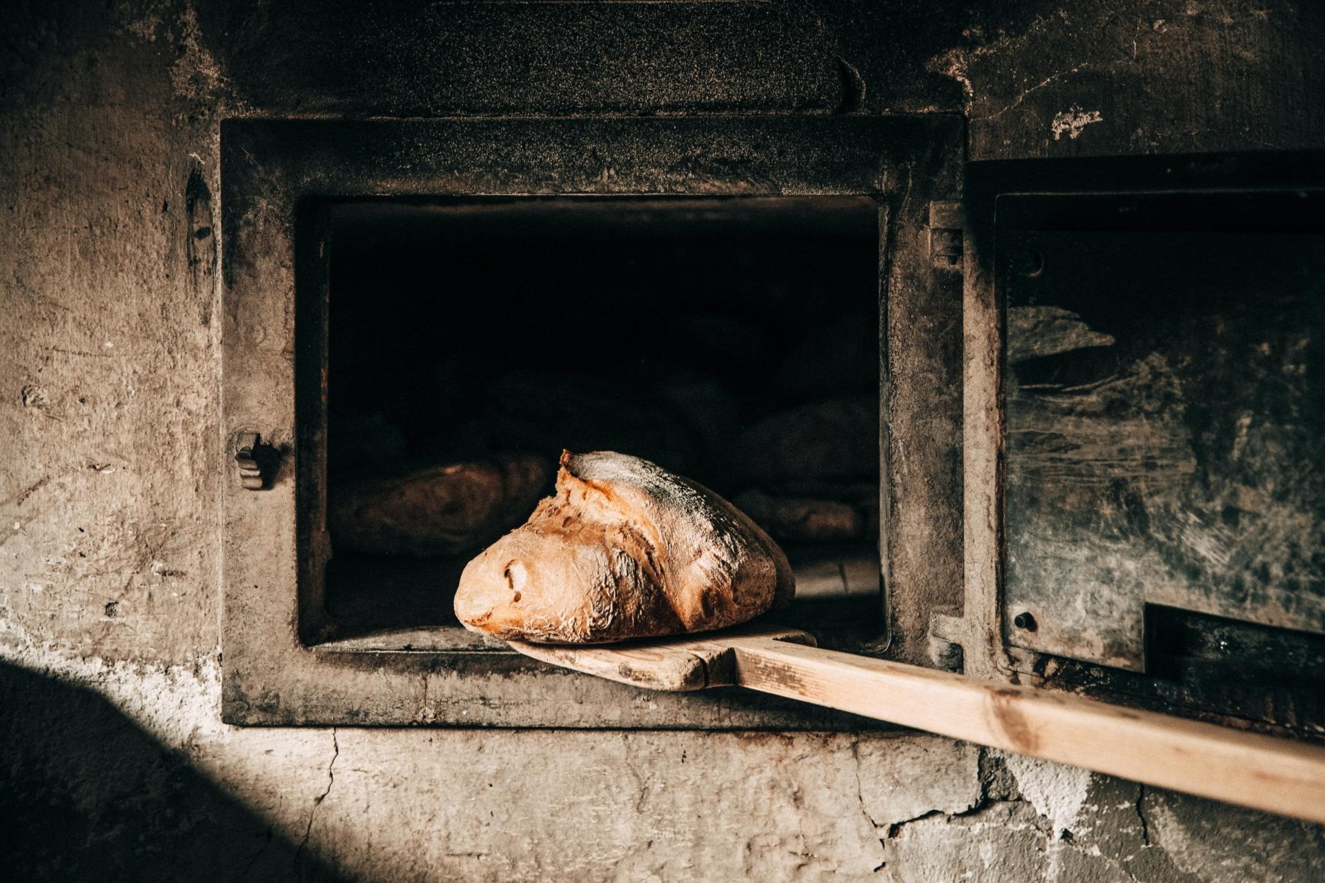 Ein Holzofen mit einem Leib Brot auf einem Brotschieber