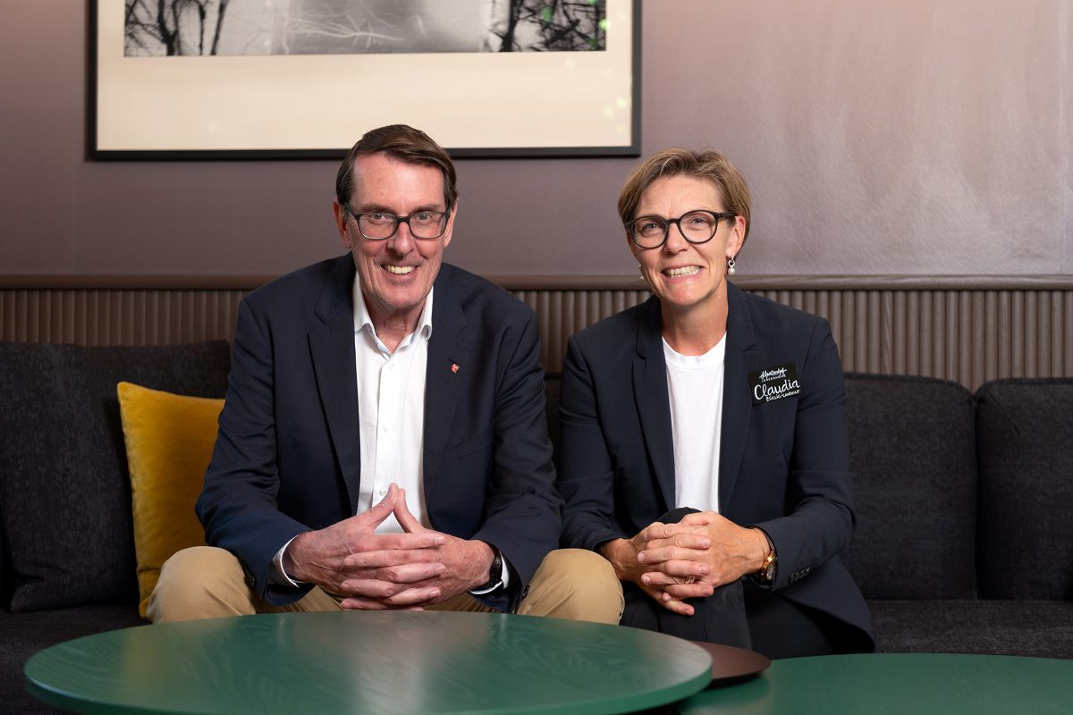 Die Besitzer des Hotel Schweizerhofes Frau und Herr Züllig lachend und sitzend.