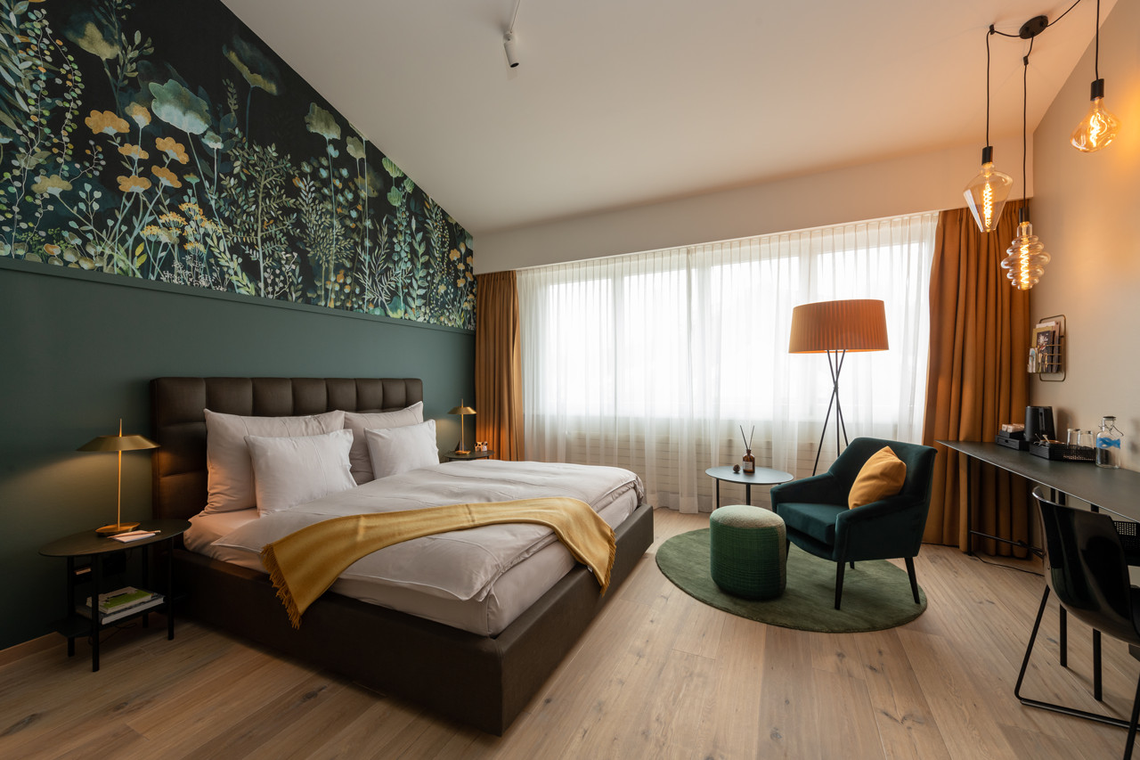 Nostalchic Belle Étage Zimmer mit elegantem Doppelbett, stilvoller Sitzgruppe und warmem Tageslicht.