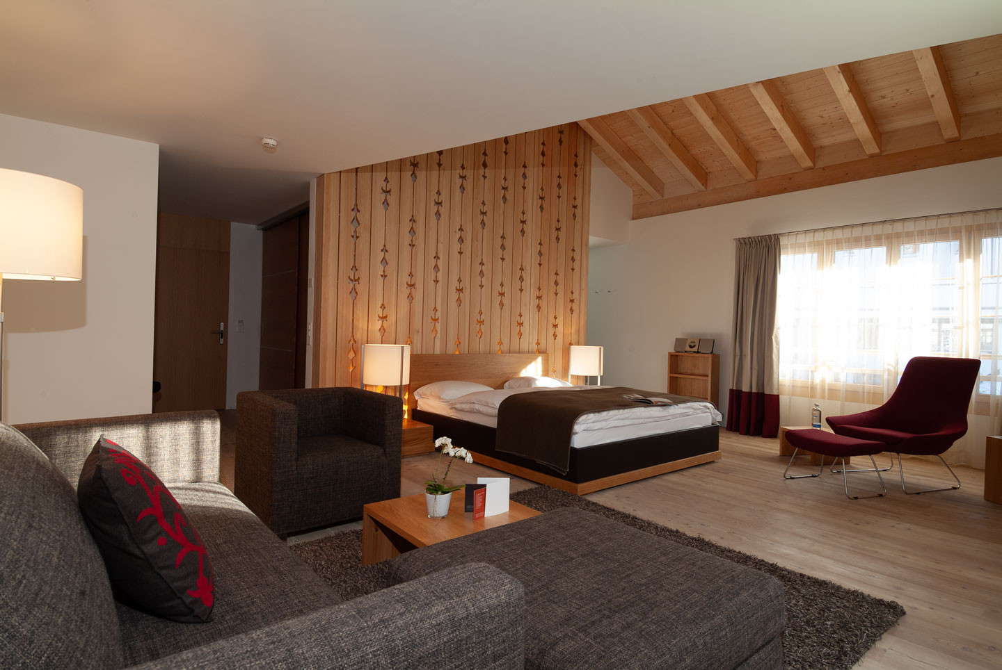 Offener Schlafbereich, gemütlicher Sitzecke und warmen Holzelementen.