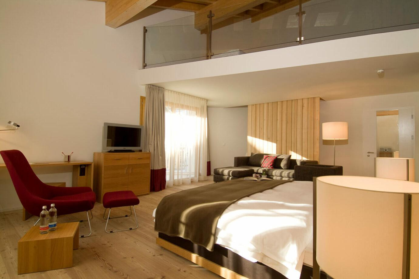 Offener Schlafbereich, gemütlicher Sitzecke und warmen Holzelementen.