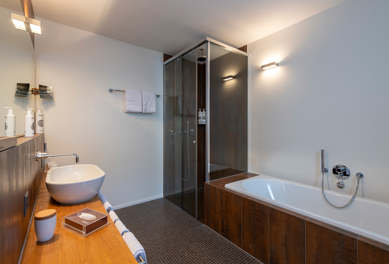 Grosszügiges Badezimmer mit Waschbecken, Badewanne und einer Dusche.