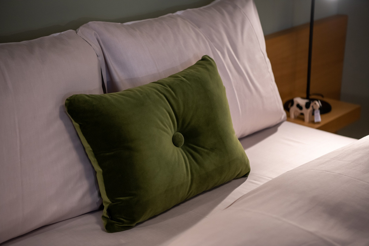 Eine Nahaufnahme des Bettes mit Kissen und Bettdecke.