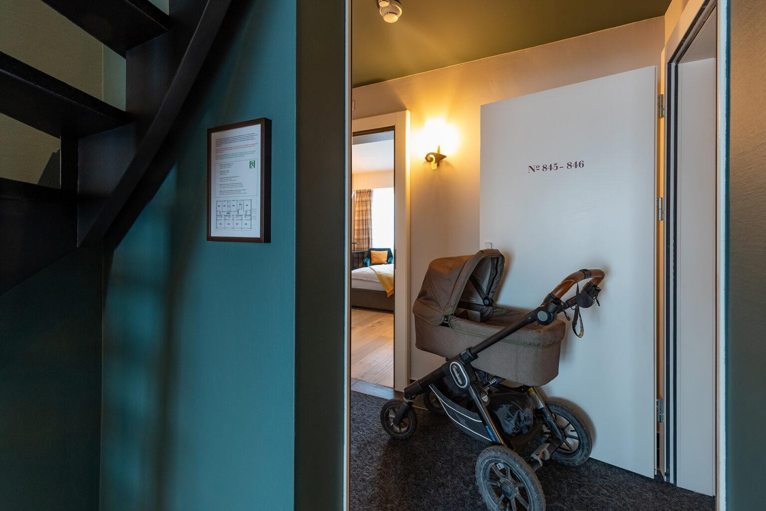 Eingangsbereich der Nostalchic Belle Étage mit Kinderwagen und Blick ins Schlafzimmer.