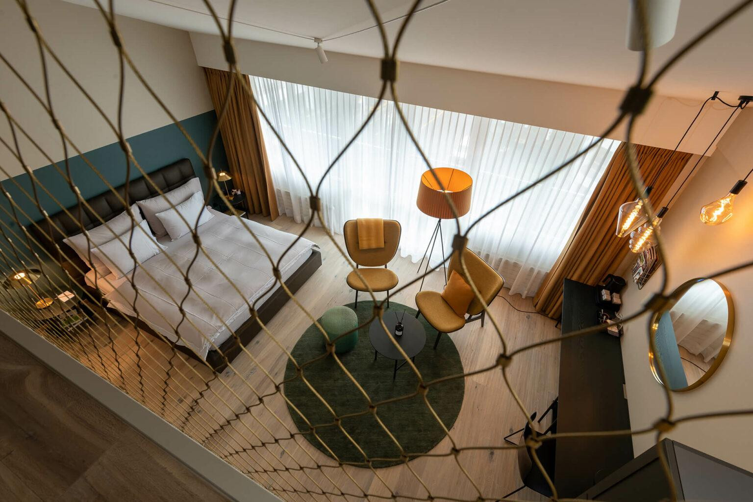 ChatGPT: Nostalchic Belle Étage Zimmer aus der Galerieperspektive mit elegantem Schlafzimmer und stilvoller Sitzgruppe.