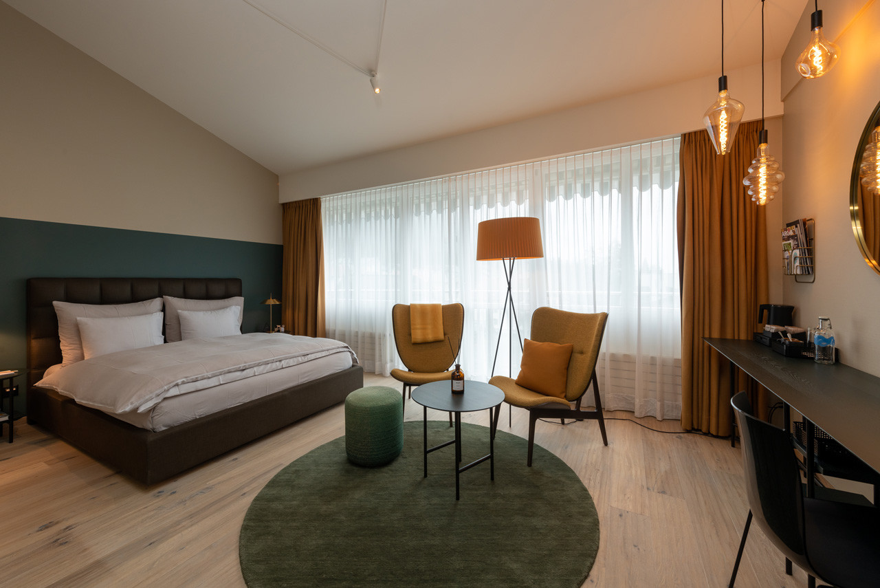 Nostalchic Belle Étage Zimmer mit elegantem Doppelbett, stilvoller Sitzgruppe und warmem Tageslicht.