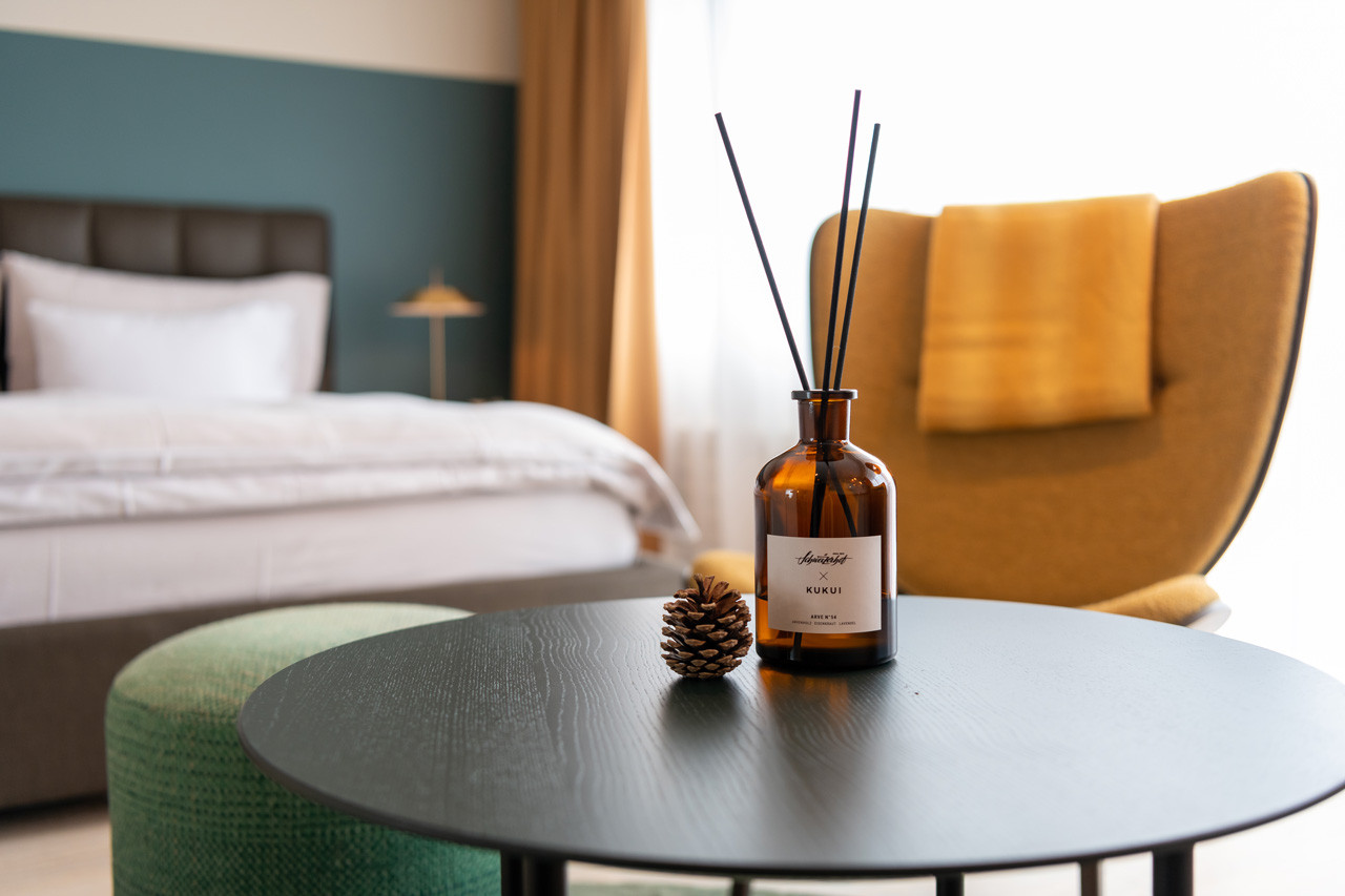 Detailaufnahme im Nostalchic Belle Étage Zimmer mit Raumduft, Tannzapfen und gemütlicher Sitzgruppe.