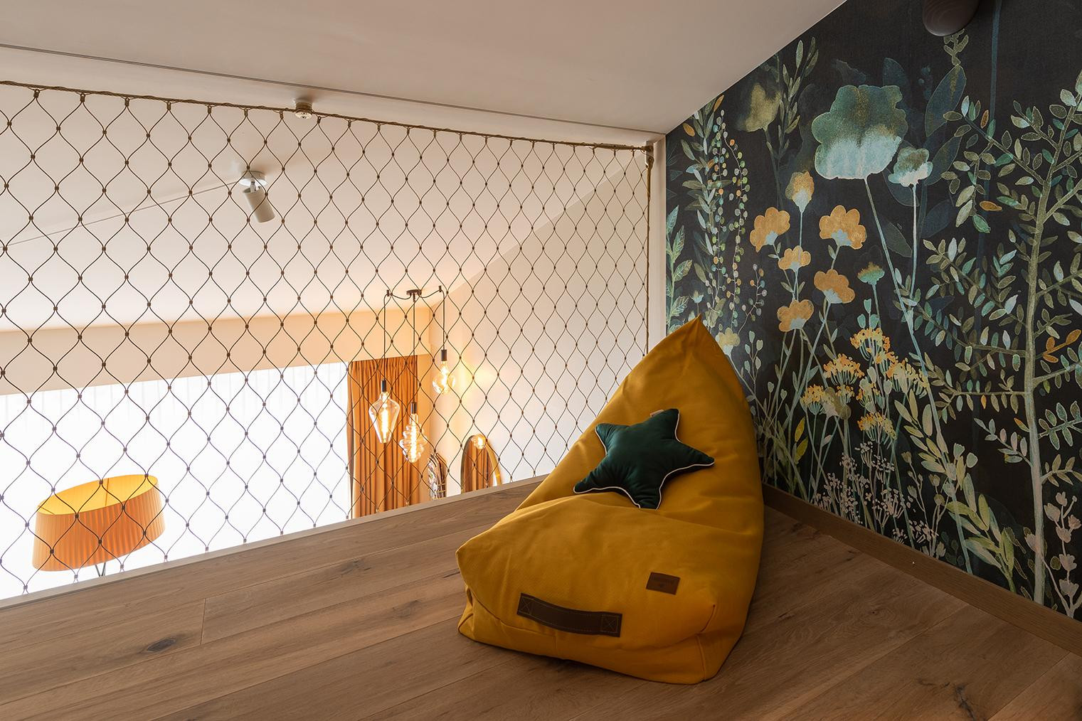 Galeriebereich im Nostalchic Belle Étage Zimmer mit gemütlichem Sitzsack und floraler Wandgestaltung.