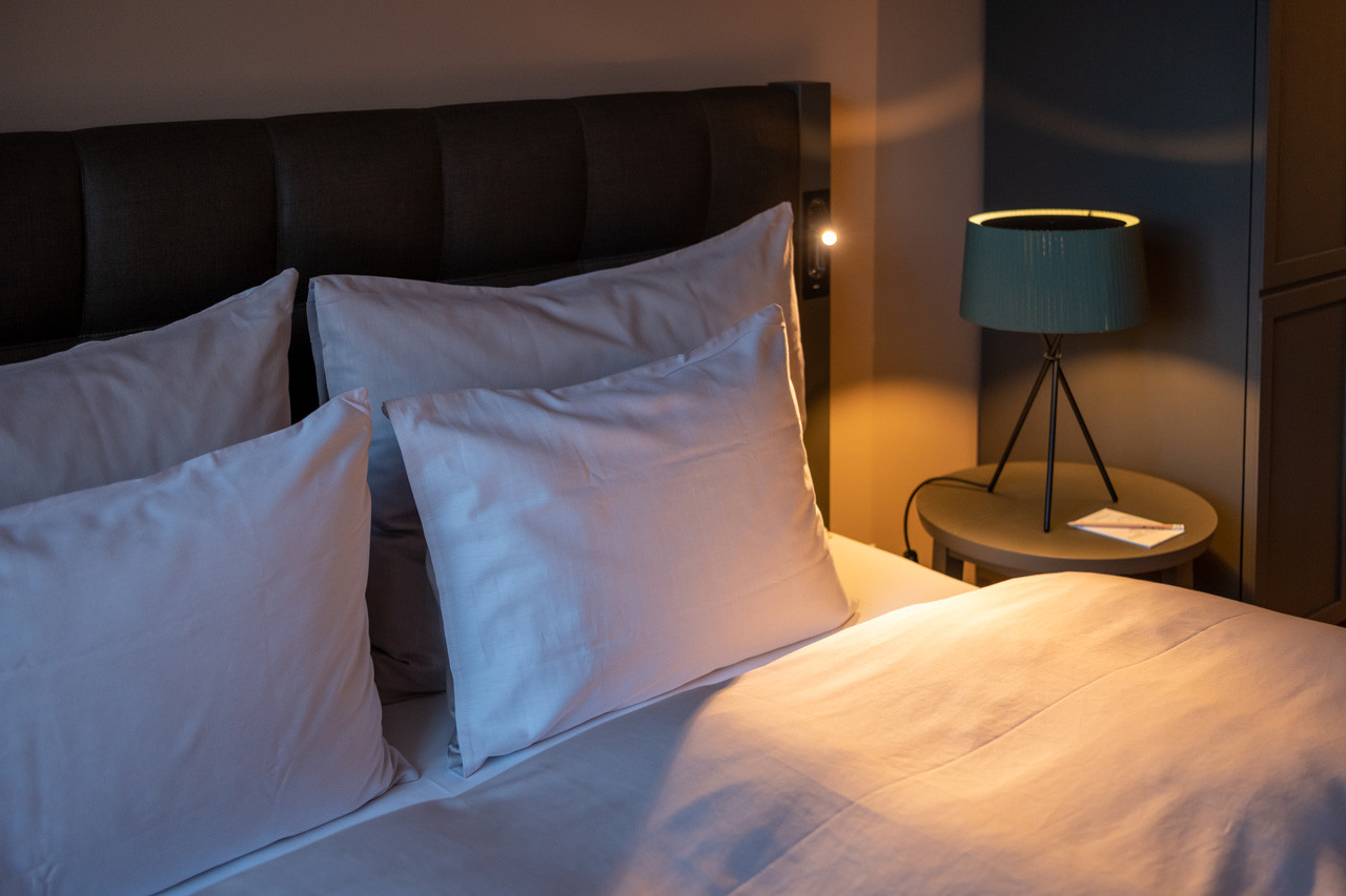 Nostalchic Zimmer mit gemütlichem Doppelbett, weicher Beleuchtung und stilvoller Nachttischlampe.