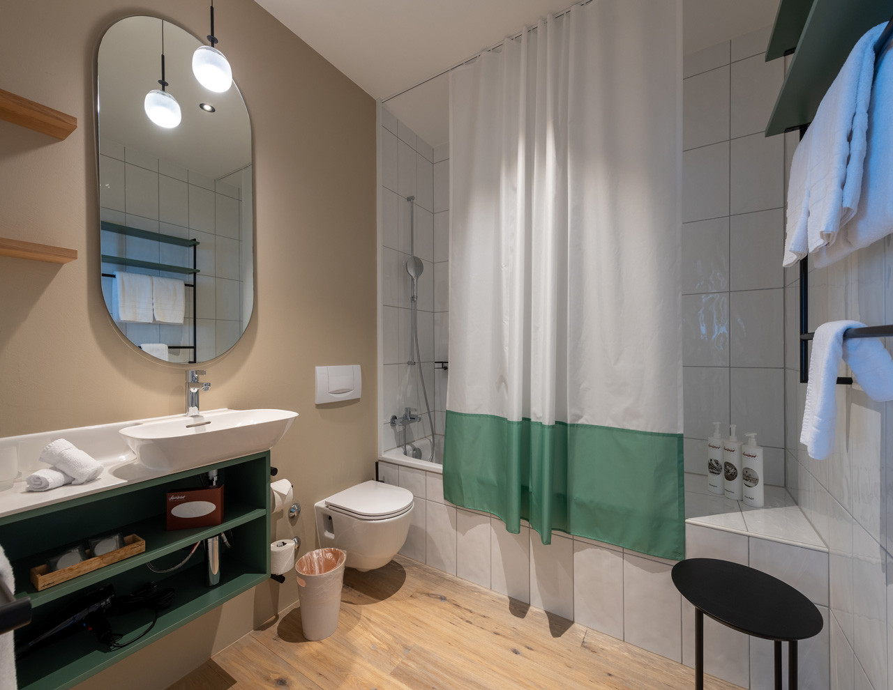 Modernes Badezimmer im Nostalchic Stil mit grossem Spiegel, Badewanne und hellen Akzenten.