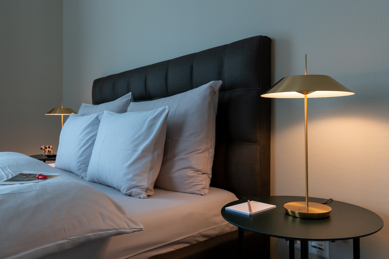 Nostalchic Zimmer mit gemütlichem Doppelbett, weicher Beleuchtung und stilvoller Nachttischlampe.