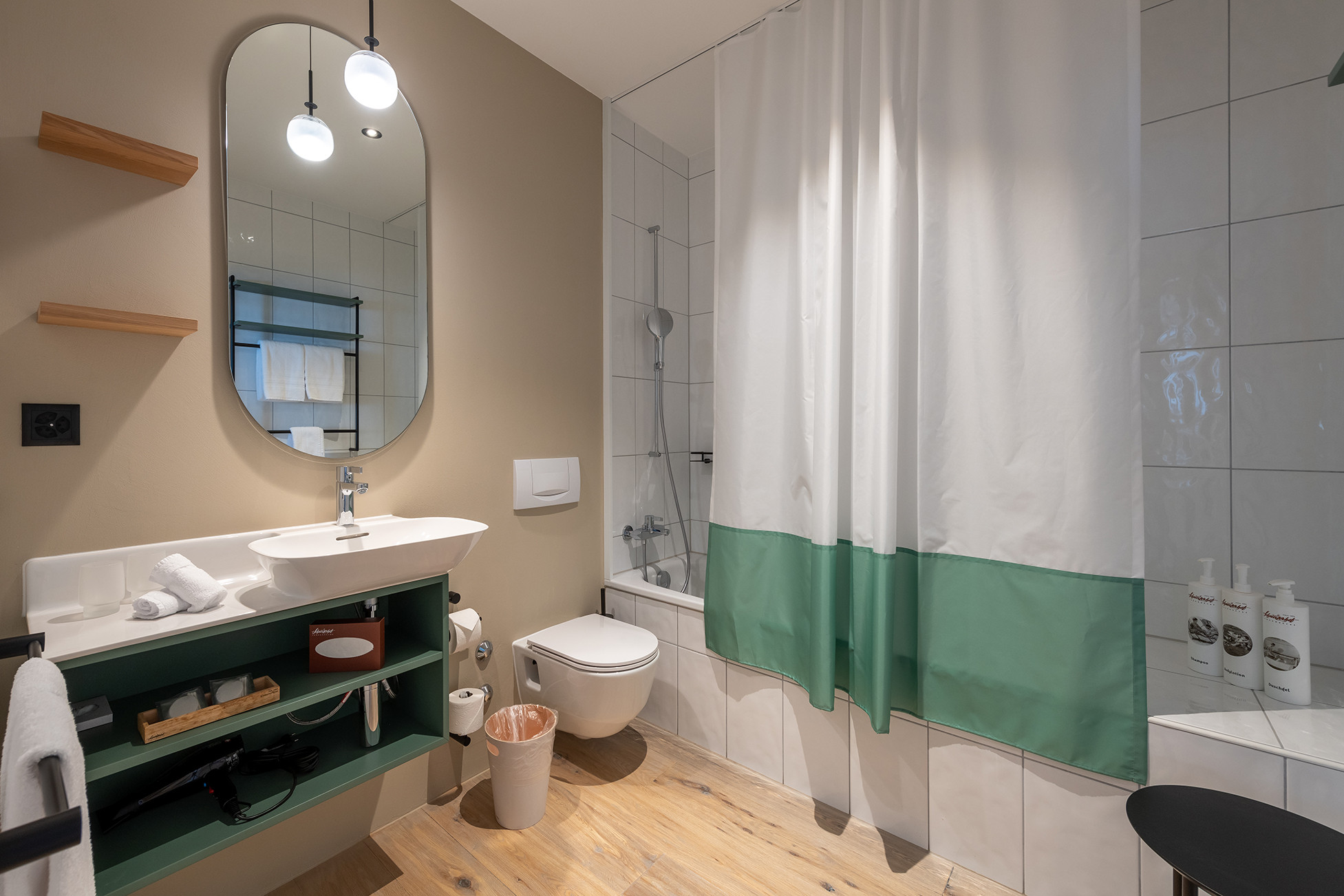 Nostalchic Zimmer mit elegantem Doppelbett, warmen Naturtönen und gemütlicher Sitzgruppe am Fenster.